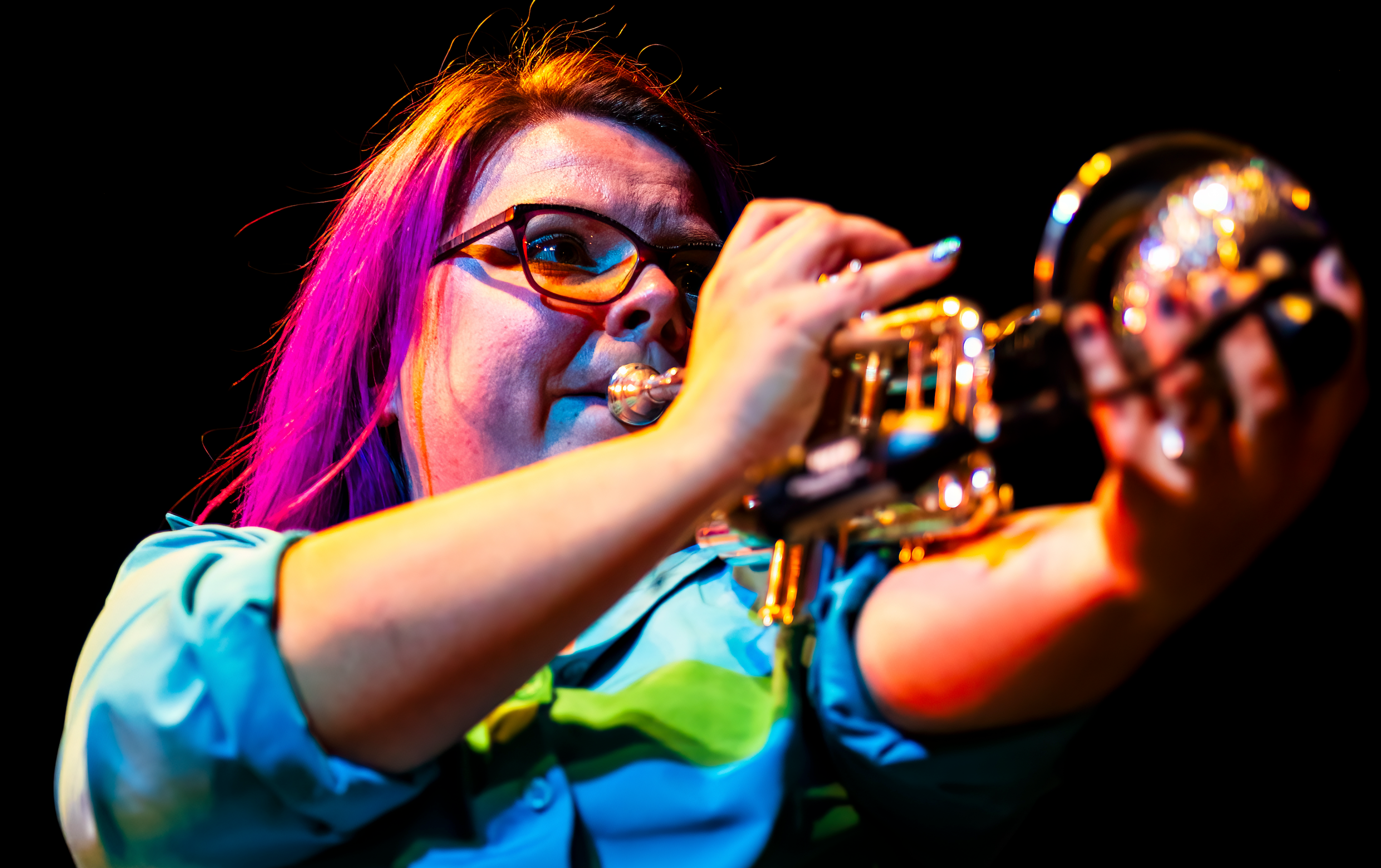 Transit Brothers horn performer with theatrical stage lighting
