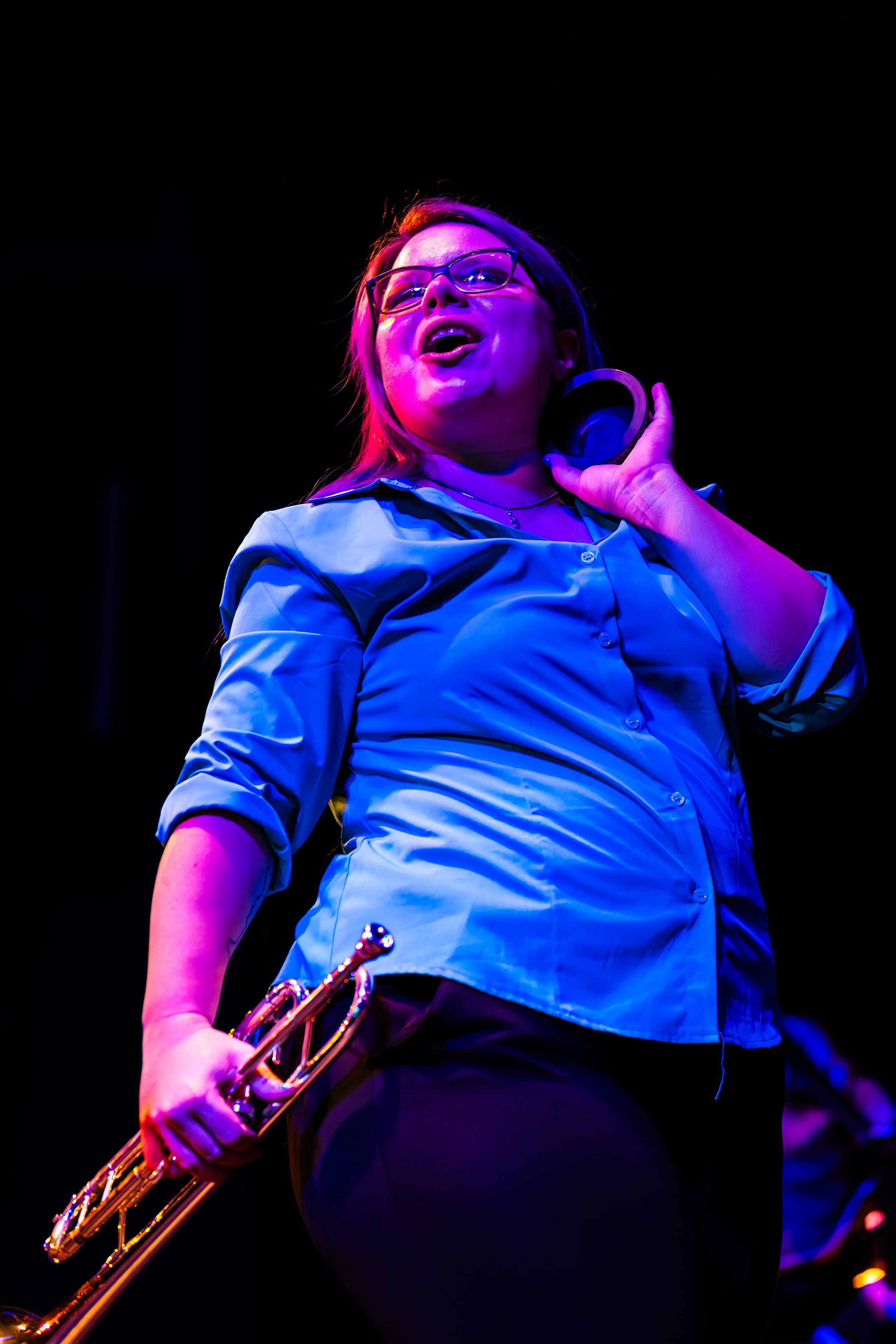 Transit Brothers trumpet performer under vivid neon stage lighting